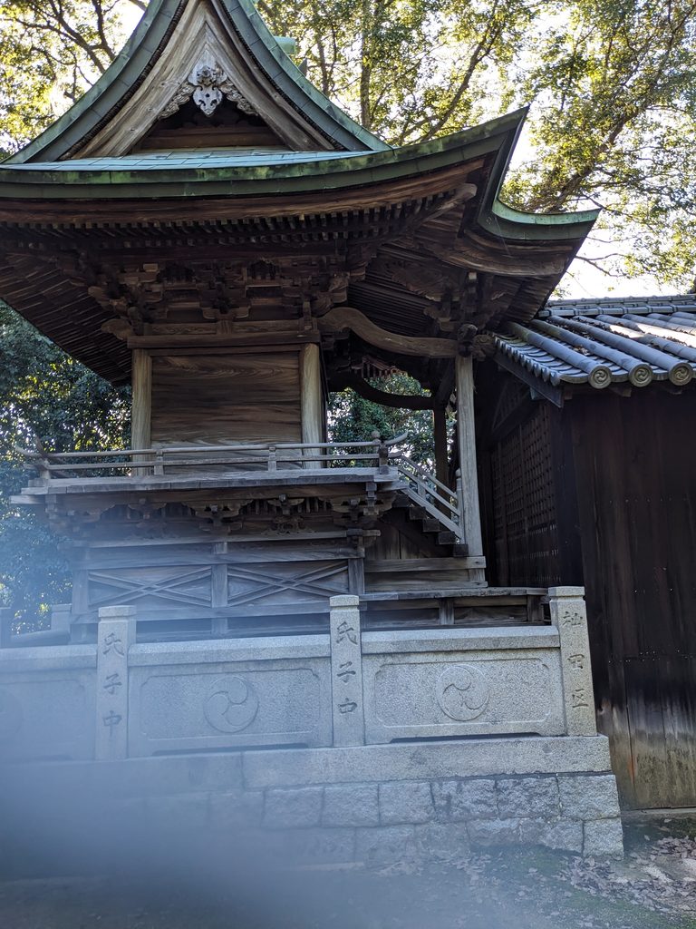 真名井神社の社殿側面に見える屋根の曲線と石造りの玉垣
