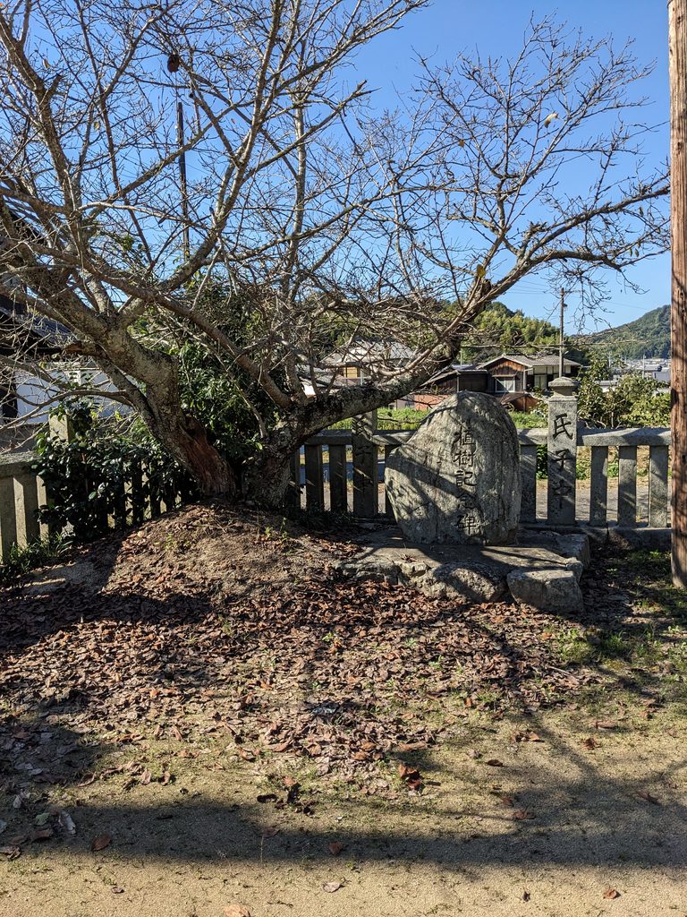 真名井神社の樹木の下に置かれた植樹記念碑と石の玉垣