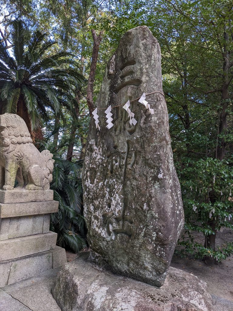 三嶋神社と刻まれた自然石の社号標と、その隣に置かれた狛犬