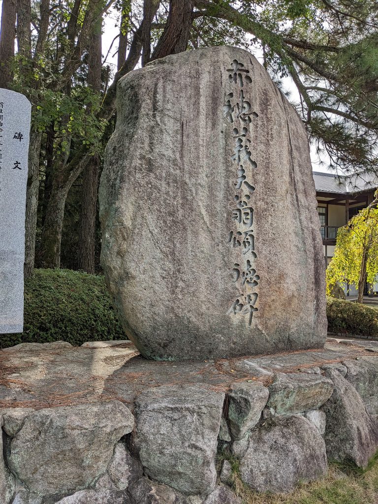 石組みの台座の上に立つ大きな石碑
